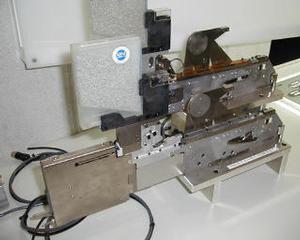 TDKのバルクフィーダー。ひとつひとつのチップを真空ポンプで吸い取って右側へ搬送、ハンダ付け工程に入る 