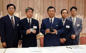CONTAX N1を手にする京セラ社長の西口泰夫氏(中央) 