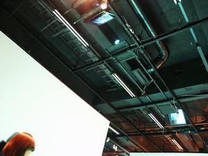 天井に据え付けられたプロジェクタとカメラ。2 画面同時出力可能なビデオカードで 2 台のプロジェクタをドライブし、広い投影面積を確保している