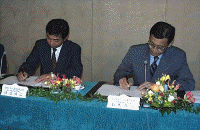 契約書にサインをする、渡辺雅治NTTデータ通信（株）第三産業システム事業部長（左）と、鈴木茂人インテュイット（株）社長（右） 