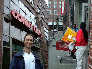 MIT近くのCompu USAに一番乗りしたKincaid氏(左)。彼はMIT出身の建築デザイナー兼Macコンサルタント。この日は母のために事前予約していたiMacを受け取りに来たが、もう1台、自分の兄弟用にも購入予定だと言う。専用の駐車場を持たないこの店では、大きな商品は客が店先に車を付けると右のようにカートで運んできてくれる 