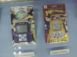 コナミの『beatmania pocket summer remix(仮）』(左)と『ポップンミュージック』(右)。今後、『ポップンミュージック』のキャラクターを使って女の子向けの文具を発売する予定 