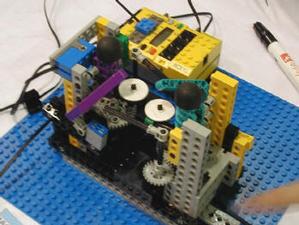 MINDSTORMSのキットとLEGOブロックを使ったゲームロボット。棒と盾で戦うもの。モーター同士を接続して、片方のモーターを動かすと一方が動く仕組みを利用している  