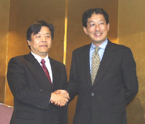 がっちりと握手を交わすジャストシステムの浮川和宣社長とマイクロソフトの成毛真社長 