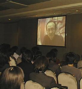 ビデオレターで挨拶をする文化庁メディア芸術プラザ美術館長の勝井氏