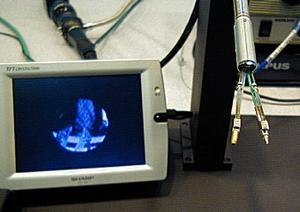 オリンパス光学工業(株)による“多自由度湾曲管状ユニット”。2本の管状ユニットのうち、右側には光ファイバーが仕込まれ、胃カメラのように配管内部を除くことができる
