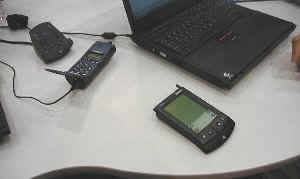 IBMブランドのPalm Pilotとノートパソコン間でのデータシンクロを行なうデモ。Ericsson製の携帯電話が使われている 