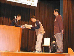 賞状を受け取る、大賞受賞者の和歌山県立串本高校商業クラブ代表、Craig Lawson君