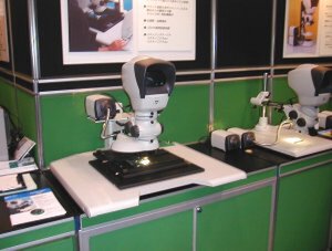 人がのぞき込む格好で使用する顕微鏡型の検査装置