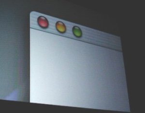 新ユーザーインターフェース“AQUA”。ウインドウの左上に赤、黄、緑の透明なボタンが表示され、それぞれウインドウのクローズ、最小化、最大化に対応する。ウインドウのスクロールバーも半透明。プルダウンメニューも半透明で、その下のウインドウが透けて見える 