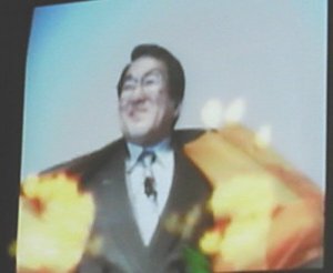 セガの佐藤常務が、着ているジャンパーの裏(オレンジ色)を見せると、その色に反応して炎の画像が表示されるというデモ 