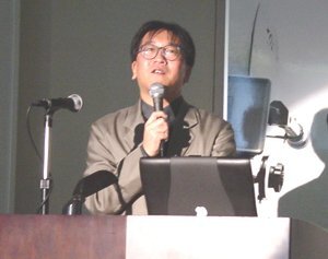特別講演に先駆けて、iWeekの発起人であり、運営委員の1人である大阪電気通信大学総合情報学部の魚井宏高助教授から来場者に向けてのあいさつと、スタッフへの感謝の言葉が述べられた