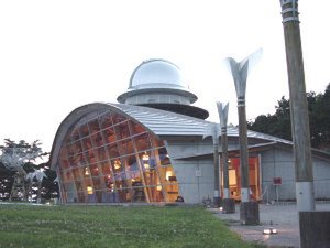 屋根の低い建物が“月の館”事務棟、セミナーハウスとして機能している。奥の丸いドームが望遠鏡のある“星の塔”。手前の芝生が観望会の行なわれる“空の庭”