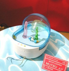 疑似ウーパールーパー飼育トイ『MUTSU』。内蔵された磁石で水中を泳ぐMUTSUは、光や音に反応、エサボタンを押すと近寄ってくる。4段階の親密度がある