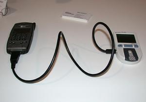 京セラのPalm OS採用携帯電話『QCP 6035』(写真左)に接続して使う血糖値測定装置(写真右)。これで血糖値を測定して携帯電話経由でデータを送信するという