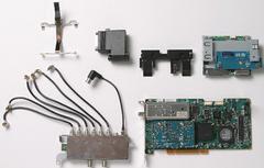 (左から)CPU固定用の金具、DVIコネクタの延長コネクタ、電源ボタン・ドア開閉ボタンの内部パーツ、メモリーカードスロット部、(下段左から)RFディストリビューター(分配機)、MPEG-2エンコーダーカード