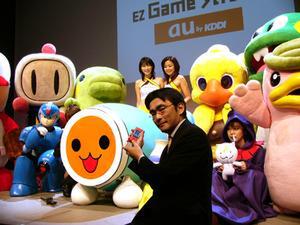 ゲームのキャラクターやコンパニオンに囲まれているのは、KDDI 執行役員コンテンツ・メディア本部長の高橋 誠氏