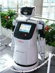 (株)富士通研究所や富士通フロンテック(株)が開発する“富士通サービスロボット”。頭部に複数搭載したカメラで周囲の人の動きを感知し、音声とタッチパネル搭載ディスプレーでサービスを提供する