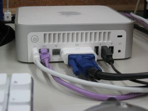 Mac miniの背面にケーブルを接続したところ。ディスプレイケーブルに若干引っ張られる感じになる。DVI-VGAアダプタを使用するとその分奥行きをとられてしまう