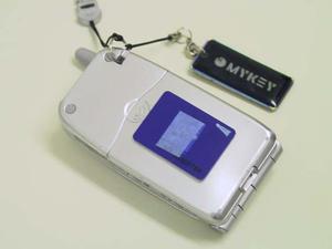 携帯電話機の裏側にも貼り付けられる小型のカードキーと、キーホルダー/携帯ストラップ型のカードキー