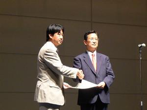 最優秀賞の表彰状を受け取る土橋氏(左)と、審査委員長の東邦仁虎 東京理科大学教授