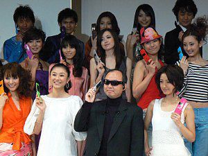 女優の菊川 怜さん（左）、上戸 彩さん（右）らに囲まれ、20色の「812SH」をアピールする孫 正義社長（中央）