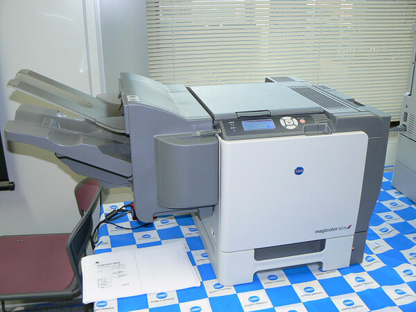 企業向けA4カラーレーザープリンター『magicolor 5570』。写真はオプションの“ステイプル機能付きフィニッシャー”を左側面に装着した状態