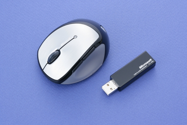 「Mobile Memory Mouse 8000」の本体とUSBレシーバ。本体中央に充電状態などを示すインジケータがある。ずんぐりむっくりとした印象だが、実際に握ると見た目以上にコンパクトだ