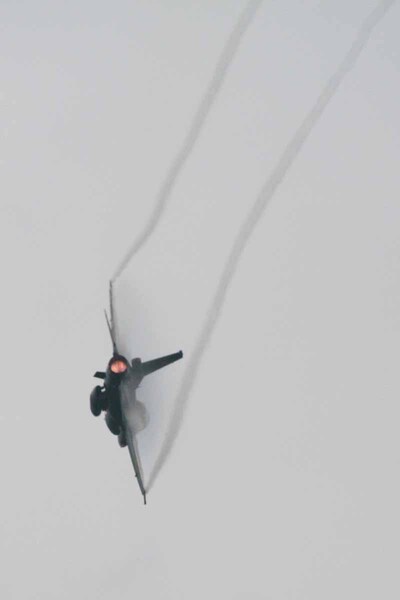機動によって翼端と機体上面に激しくヴェイパーを発生させて飛行しているF-2A