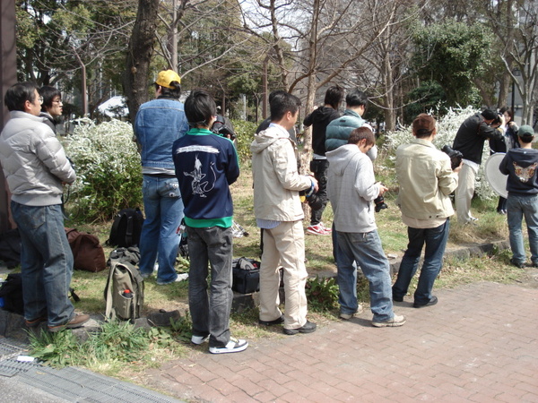 屋外の撮影会でたくさんの参加者が自分の順番を待っているところ