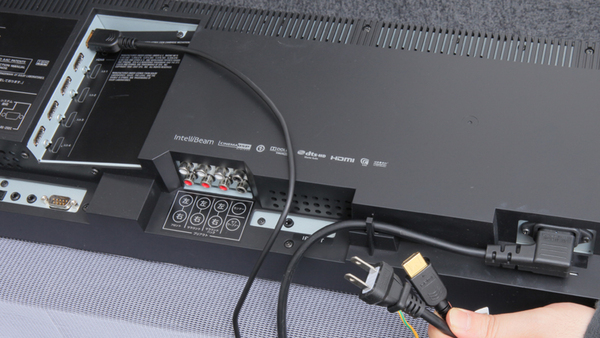 「YSP-4100」をテレビと接続しているところ。基本的な接続は電源とHDMIケーブルだけ。あとはテレビ音声用のデジタル音声ケーブルの接続やBDレコなどとの接続を行なう 