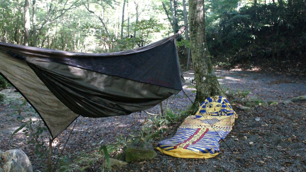自前のテント（ハンモック）と寝袋を撮影。撮影場所は木陰だが、奥の方は明るい日差しが差し込んでいる。こうした逆光気味の撮影でも、ややノイズのチラつきがある