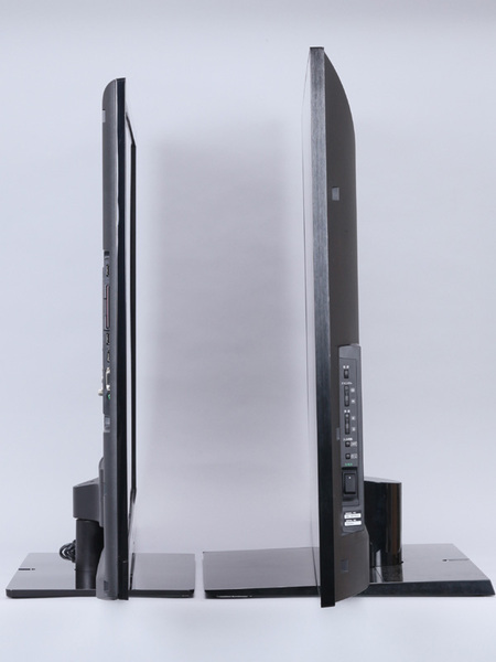 「KDL-46EX720」（左）と「KDL-46LX900」（右）のディスプレー部の厚みの比較。LX900の64mmに対してEX720は42mmと、明らかに薄くなっていることがわかる。また、同じ画面サイズながらLX900は高さが761mmであるのに対し、EX720は690mmと低くなっている（いずれもスタンド込み）。ちなみに、重量もLX900は28.4kgであるのに対してEX720は17.9kgと10kg以上の差がある