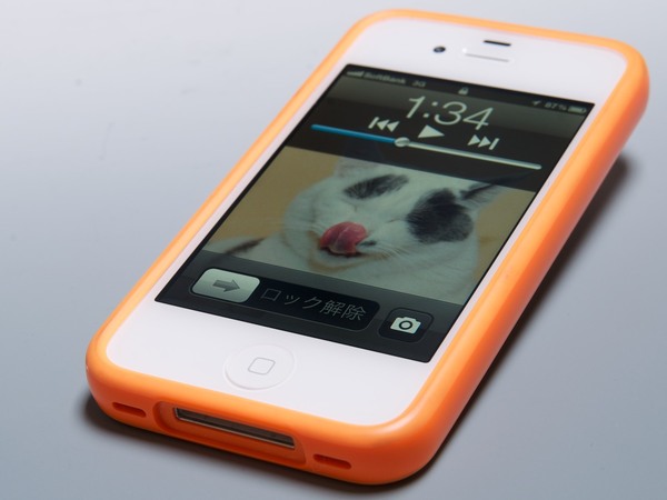ホワイトのiPhone 4Sにオレンジのアップル純正バンパーを装着。バンパーをつけると滑りにくいし落としても壊れにくくなるので重宝してる。ロック画面にあるカメラアイコンに注目