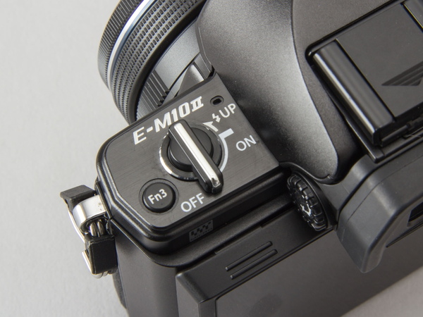 左側にある電源スイッチは、銀塩カメラの「OM-1」を彷彿させるデザイン。ストロボのポップアップスイッチも兼ねている