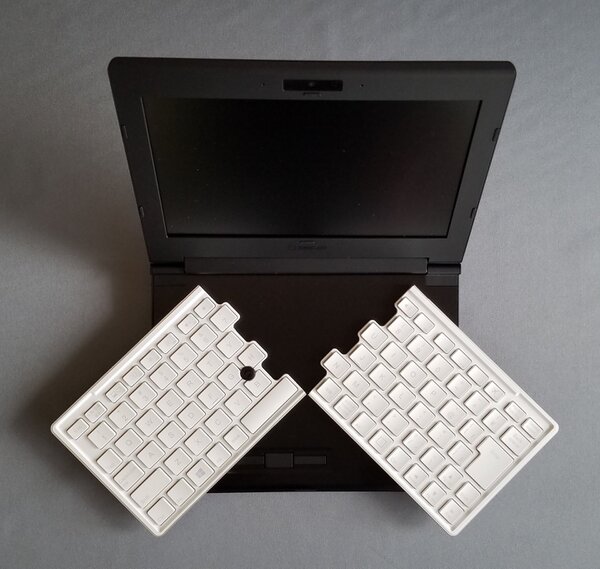 両手で左右に分割されたキーボードの手前の左CtrlキーとEndキーを持って広げる