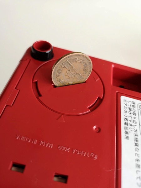貯金箱に貯まったコインは、底面の蓋をコインなどでねじって開けて取り出す