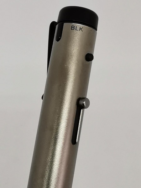 2色のボールペンはこの金属製のレバーを先端方向に押し下げることで目的のカラーの芯先が露出する。「BLK」の文字が見えている状態なら黒芯が出る