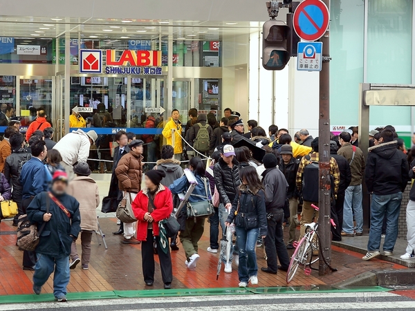 店舗入口の買い物客と報道陣