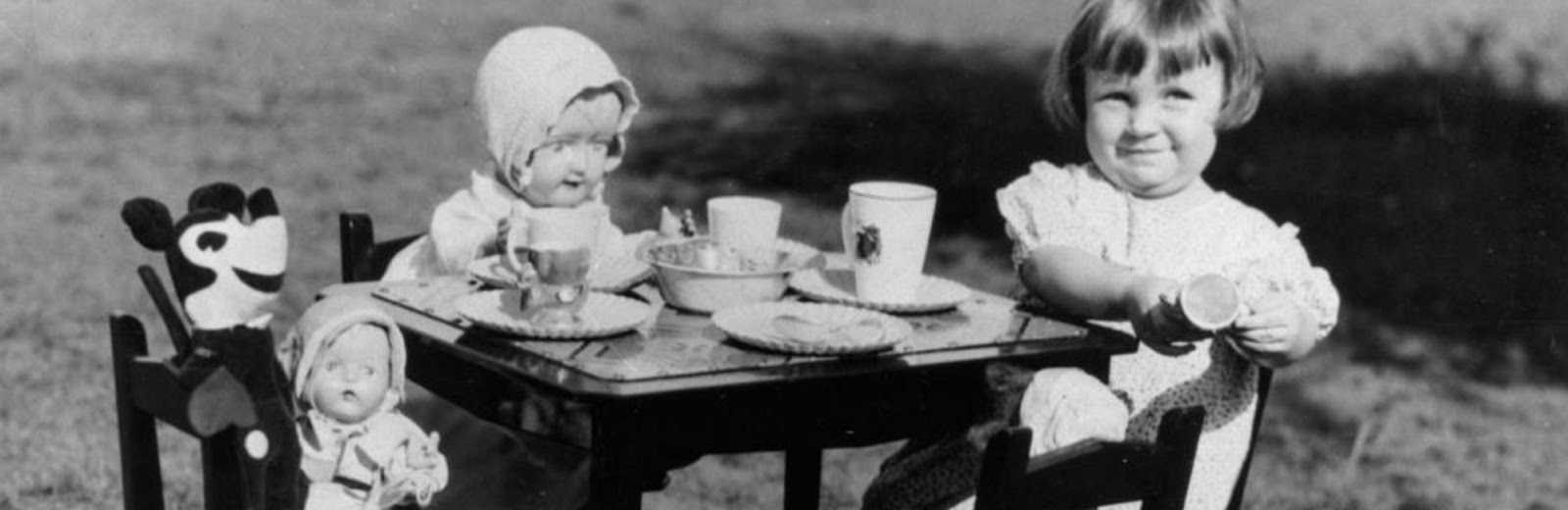 Young girl entertaining Mickey Mouse and other friends at a make-believe tea party, 1930s