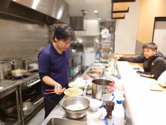 スーパーバイザーたちが見守るなか、一杯一杯慎重にラーメンを作る藤橋さん