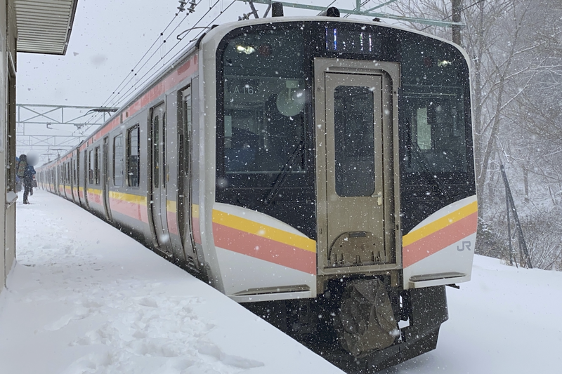 雪の舞うホームに佇む列車