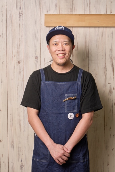 店主の大山貴幸さん。伊吹いりこ推しの店らしく、エプロンには煮干のブローチを付けている